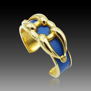 Bracelet Hermes Métal Doré Rigide ouvert avec cuir bleu . Bracelet Hermes Métal Doré Rigide ouvert avec cuir bleu .