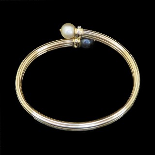 Bracelet rigide en or jaune 18k avec 2 perles de culture et diamants brillants .