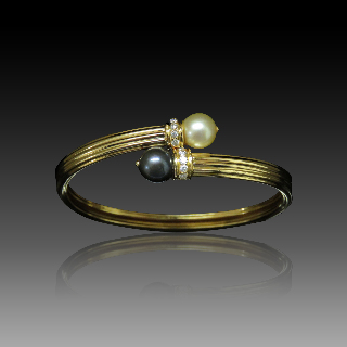 Bracelet rigide en or jaune 18k avec 2 perles de culture et diamants brillants .