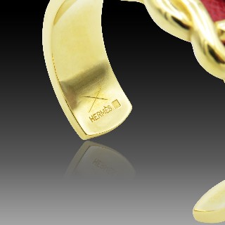 Bracelet Hermes Métal Doré Rigide ouvert avec cuir rouge . Bracelet Hermes Métal Doré Rigide ouvert avec cuir rouge .
