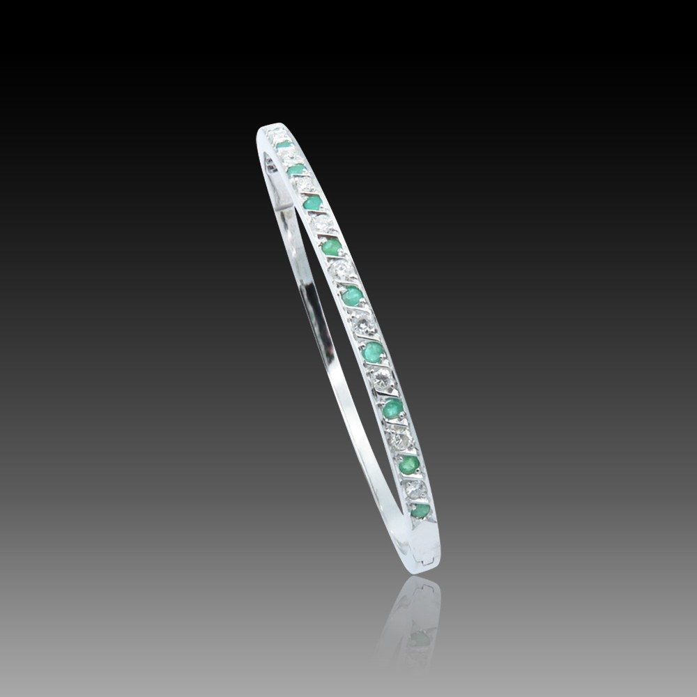 Bracelet ouvrant rigide en or gris 18 Cts avec émeraudes et diamants brillants .